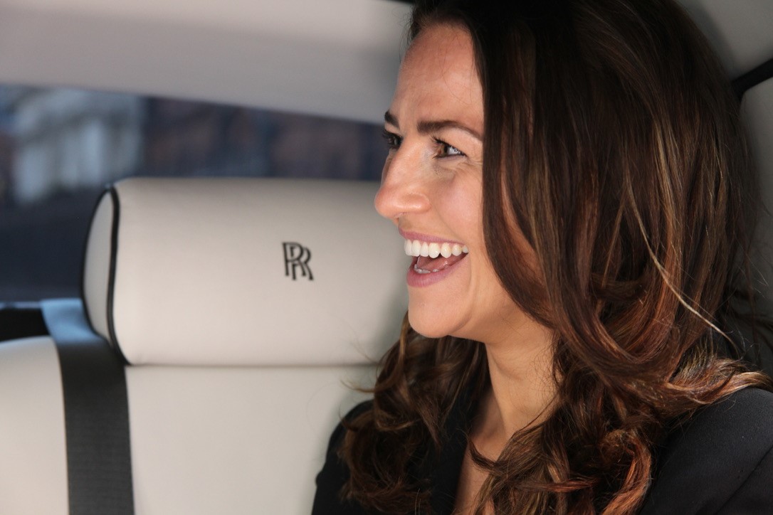 Client smiling on the backseat of a Rolls-Royce Phantom