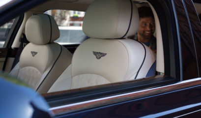 Happy chauffeur passenger in back of Bentley Mulsanne