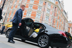 Chauffeur holding open door of Mercedes S-Class