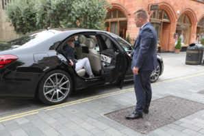 Chauffeur opening door for passenger of Mercedes S-Class