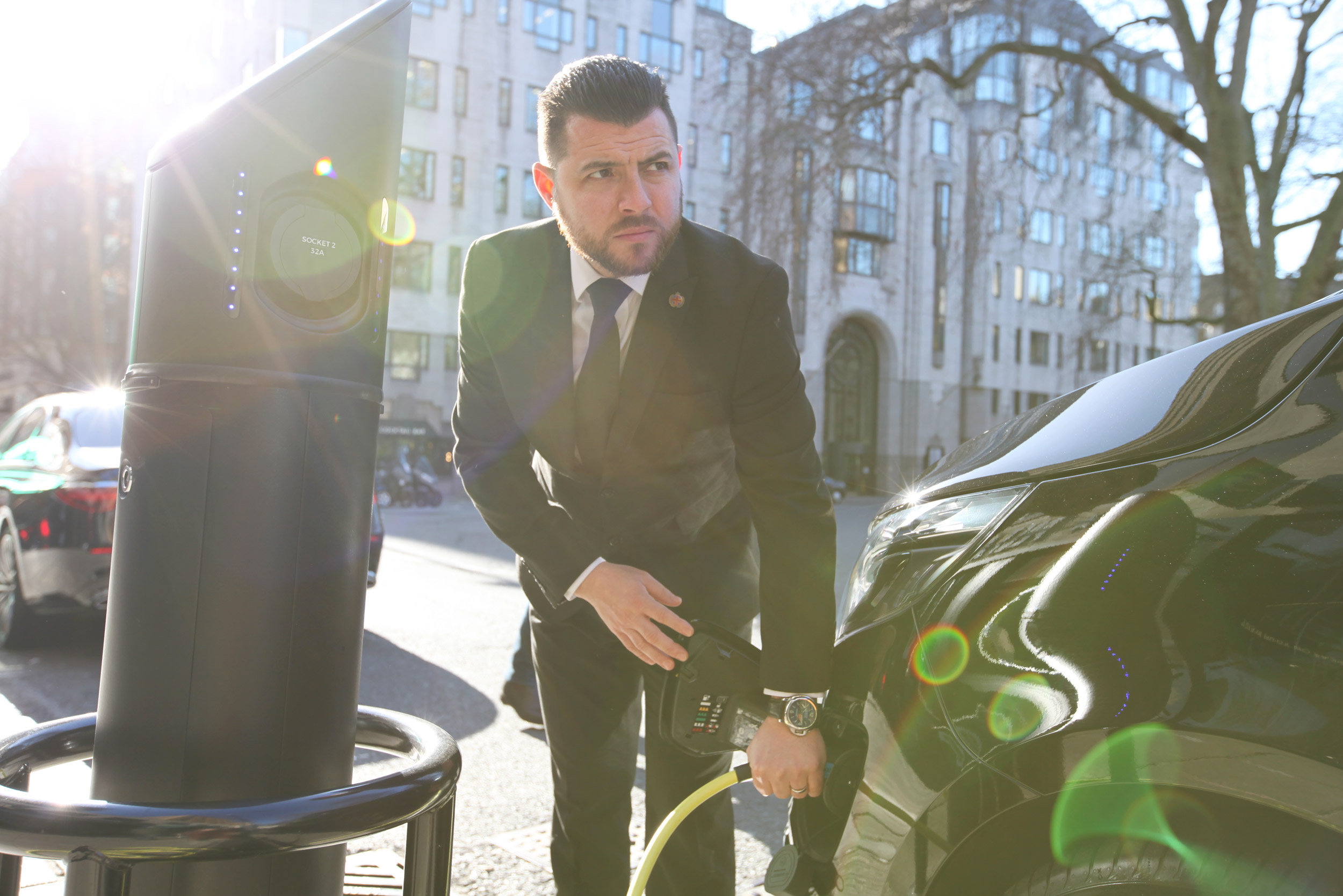 Chauffeur charging luxury electric Mercedes EQV in Central London