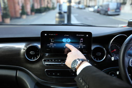 Chauffeur pointing to EQ graphic on Mercedes EQV screen in London