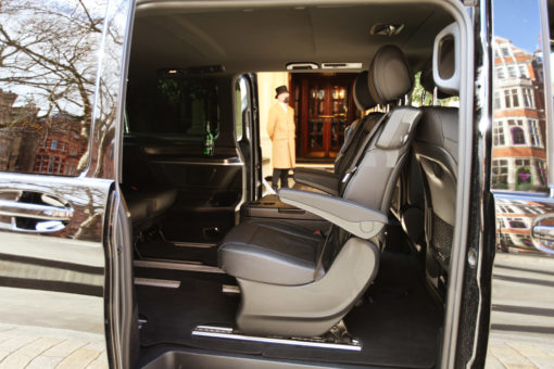 Mercedes EQV luxury interior with view through to of doorman of Connaught Hotel, Mayfair, London