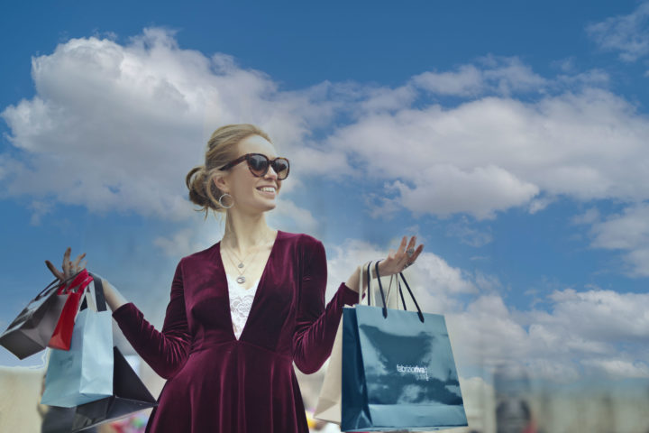 Smiling shopper happily carrying her bags