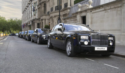 Six black Rolls-Royce Phantom chauffeur cars parked in a line on a London street