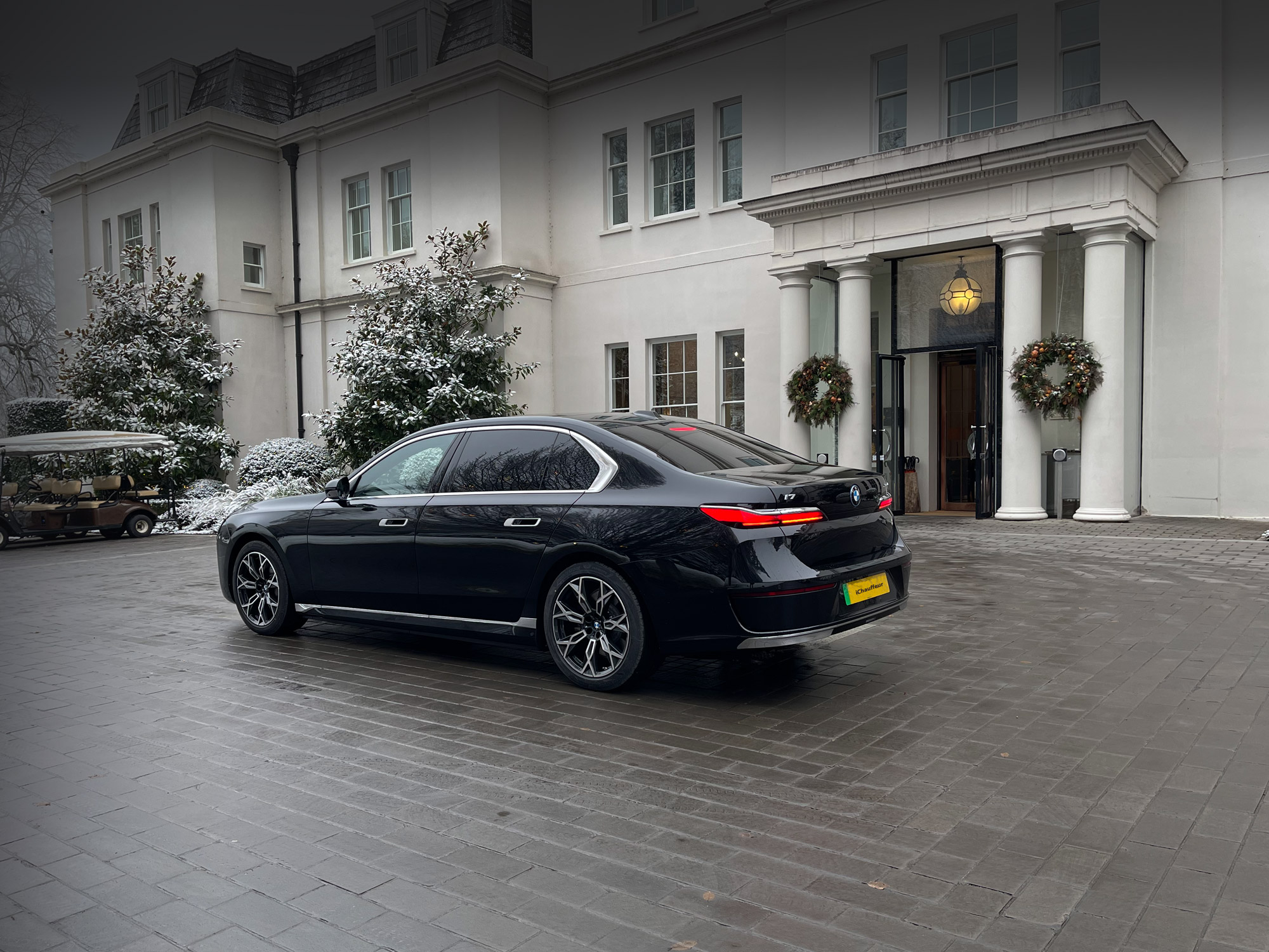 Black BMW i7 chauffeur car in front of Coworth Park, Ascot.
