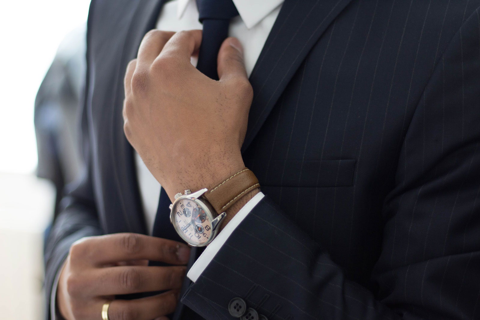 Suited chauffeur adjusting tie