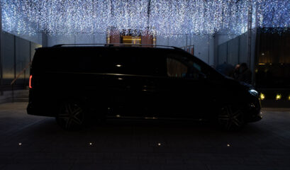 Black Mercedes V-Class at night under sparkling lights