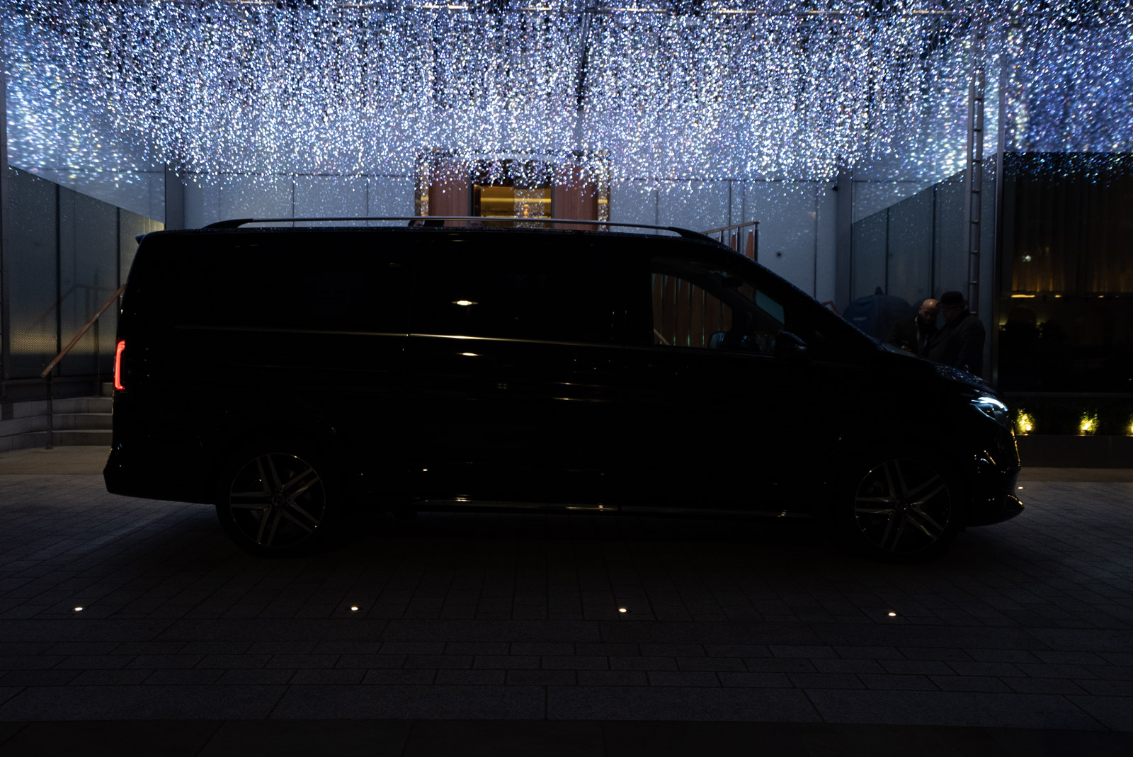 Black Mercedes V-Class at night under sparkling lights