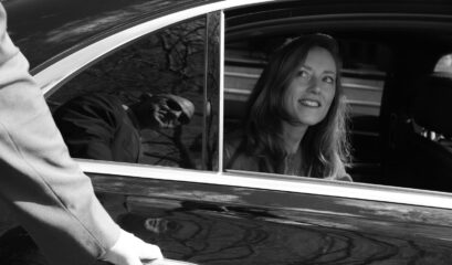 Passenger smiling as chauffeur opens her car door