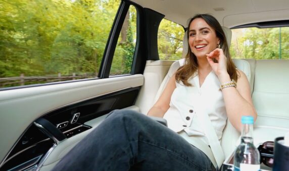 Smiling passenger in back of luxury chauffeur car